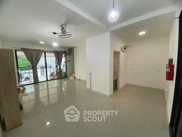 Spacious modern living room with large windows and sleek tile flooring