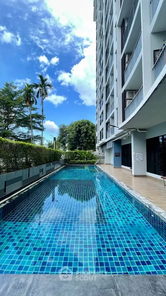 Luxurious high-rise building with stunning outdoor pool and lush greenery.
