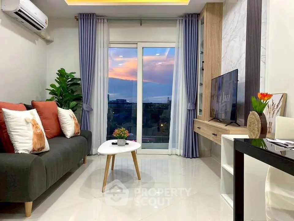 Modern living room with stylish decor and sunset view through large window.