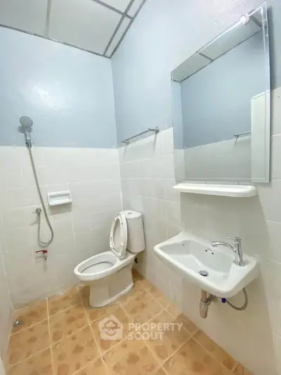 Modern bathroom with white tiles, shower, and sleek fixtures in a contemporary home.
