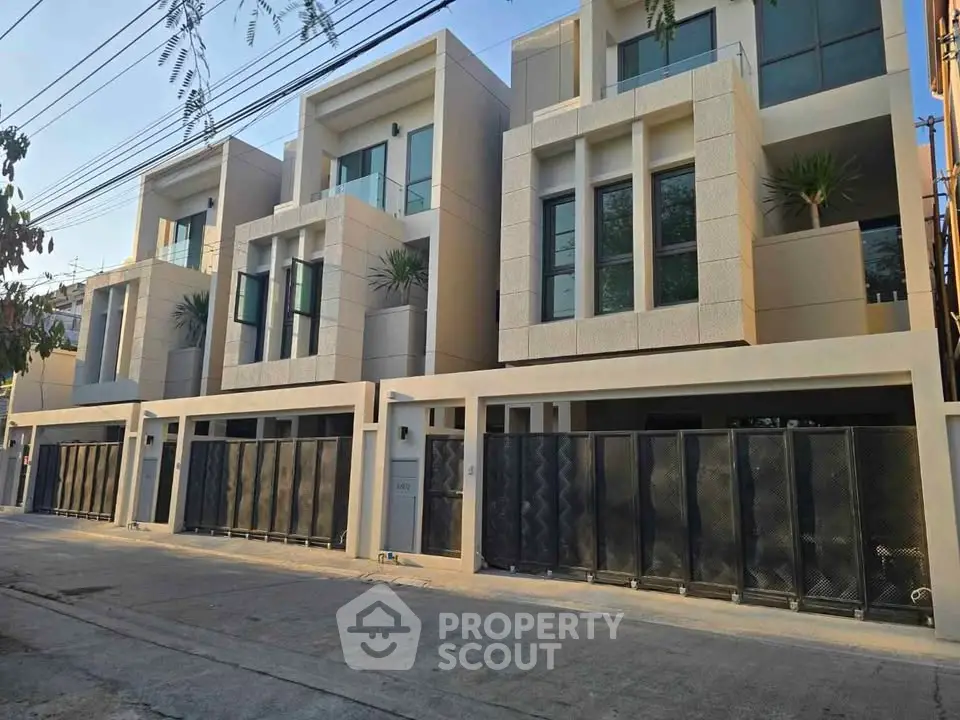 Modern townhouse exterior with sleek design and large windows in a serene neighborhood.