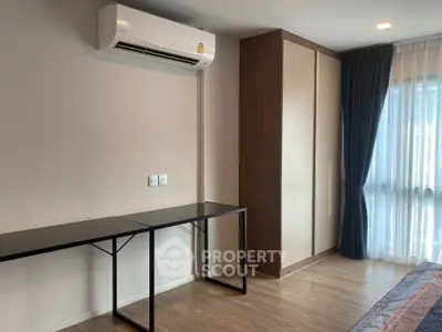 Modern bedroom with air conditioning and large window for natural light