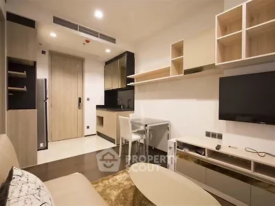 Modern living room with sleek furniture and open kitchen layout in a stylish apartment.
