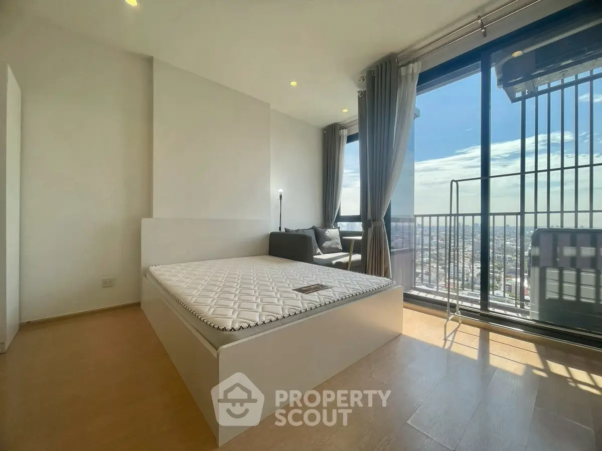 Spacious bedroom with stunning city view and large windows for natural light.