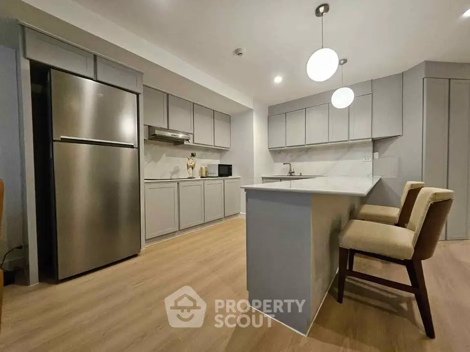 Modern kitchen with sleek cabinetry and stainless steel appliances in a stylish apartment.