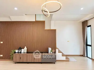 Modern living room with stylish wooden paneling and elegant lighting fixture