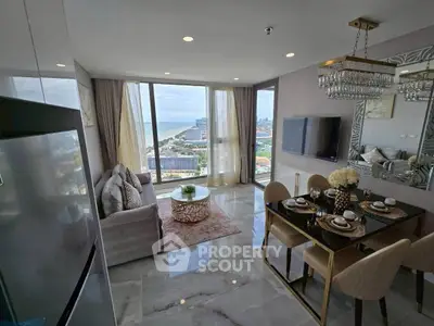 Luxurious living room with ocean view, elegant dining area, and modern decor in high-rise apartment.