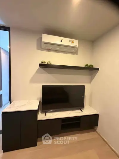 Modern living room with sleek TV unit and air conditioning, perfect for cozy relaxation.