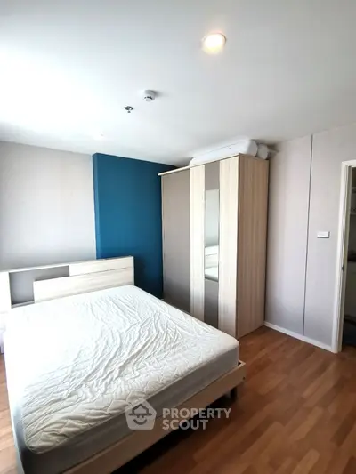 Modern bedroom with wooden flooring and stylish wardrobe in a cozy apartment.