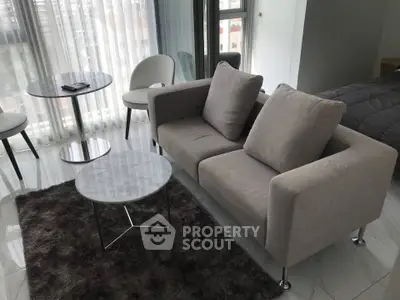 Modern living room with sleek furniture and large windows offering natural light.