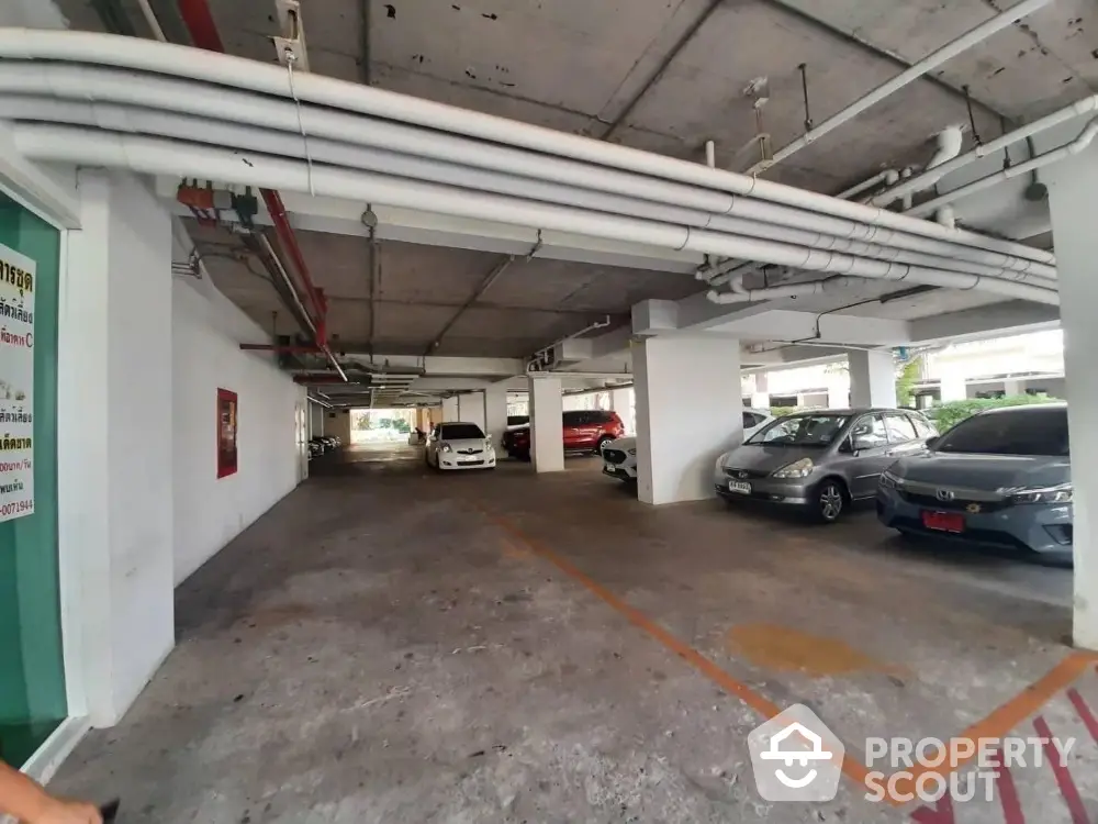 Spacious indoor parking area with multiple vehicles in a modern building.