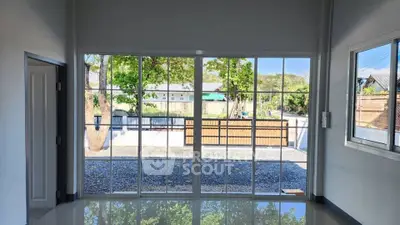 Spacious room with large glass doors opening to a serene garden view.