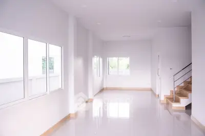 Spacious modern living room with large windows and sleek staircase