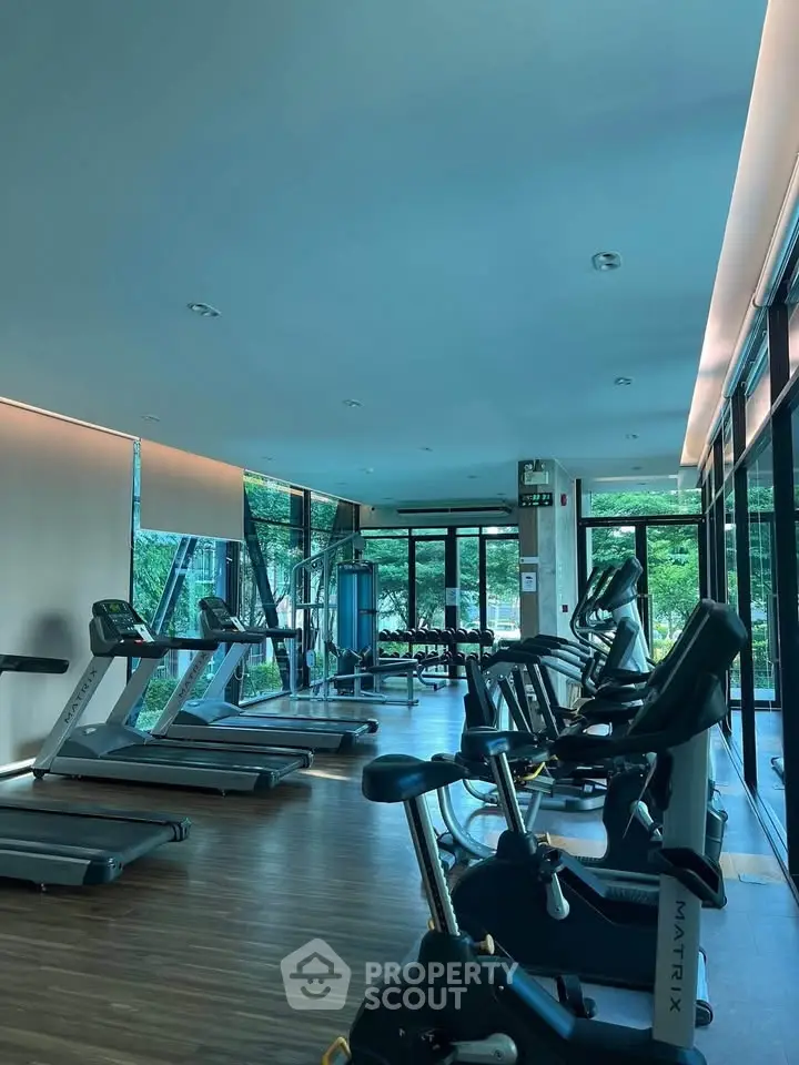 Modern gym with state-of-the-art equipment and large windows offering a scenic view.
