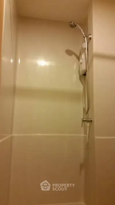 Compact bathroom shower area with modern fixtures and sleek design.
