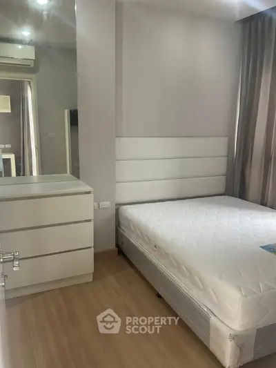 Modern bedroom with minimalist design featuring a comfortable bed and sleek dresser.