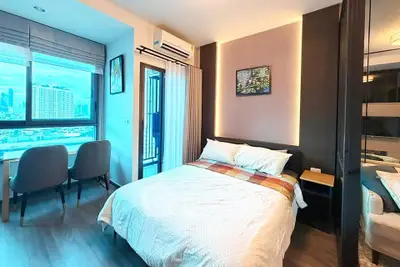 Modern bedroom with city view, featuring cozy bed and stylish decor in urban apartment.
