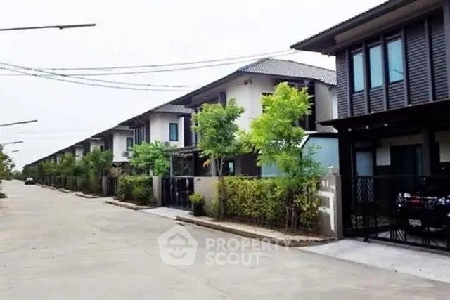 Modern residential street with contemporary houses and lush greenery.