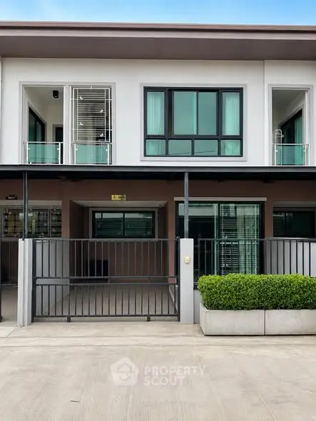 Modern townhouse exterior with sleek design and gated entrance, perfect for urban living.