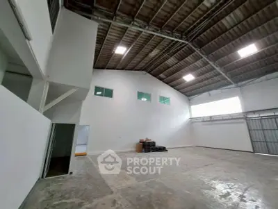 Spacious industrial warehouse with high ceilings and ample natural light, perfect for storage or manufacturing.