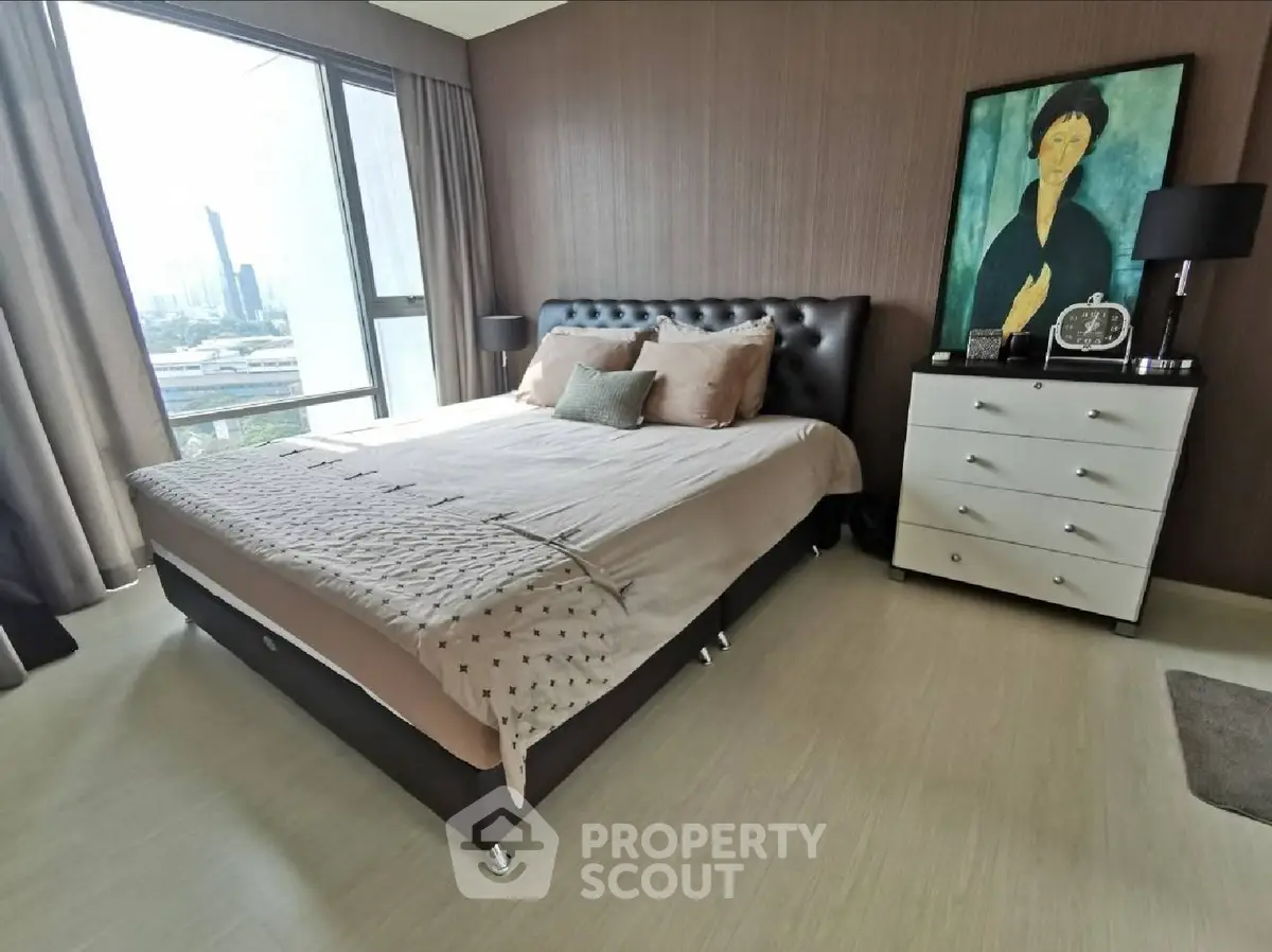 Luxurious bedroom with stylish decor and city view, featuring a plush bed and elegant dresser.