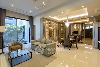 Luxurious open-plan living and dining area with elegant furnishings and modern lighting.