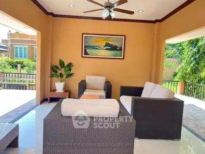 Charming living room with cozy wicker furniture and scenic artwork, perfect for relaxation and entertaining.