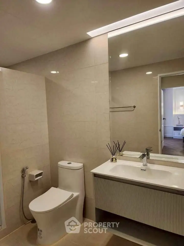 Modern bathroom with sleek fixtures and elegant design, featuring a spacious vanity and contemporary lighting.