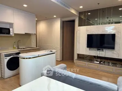 Modern living room with open kitchen, featuring sleek appliances and elegant decor.