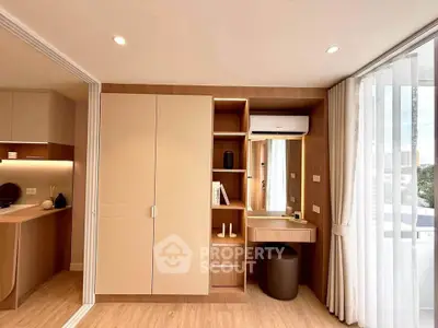 Modern bedroom with built-in wardrobe and vanity, featuring sleek design and natural light.