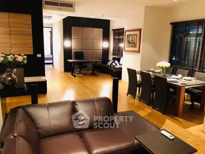 Luxurious open-plan living and dining area with elegant furnishings and warm lighting.