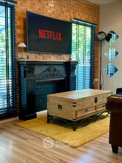 Stylish living room with brick wall, modern decor, and Netflix-ready TV setup.
