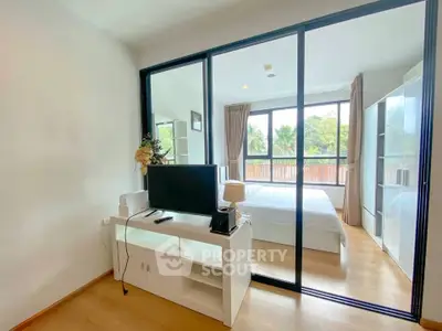 Modern bedroom with glass partition and scenic view, featuring sleek furniture and abundant natural light.