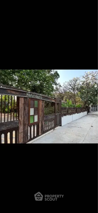Charming rustic wooden gate with lush greenery, perfect for a serene home entrance.