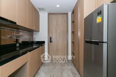 Modern kitchen with sleek cabinetry and stainless steel appliances in a stylish apartment.