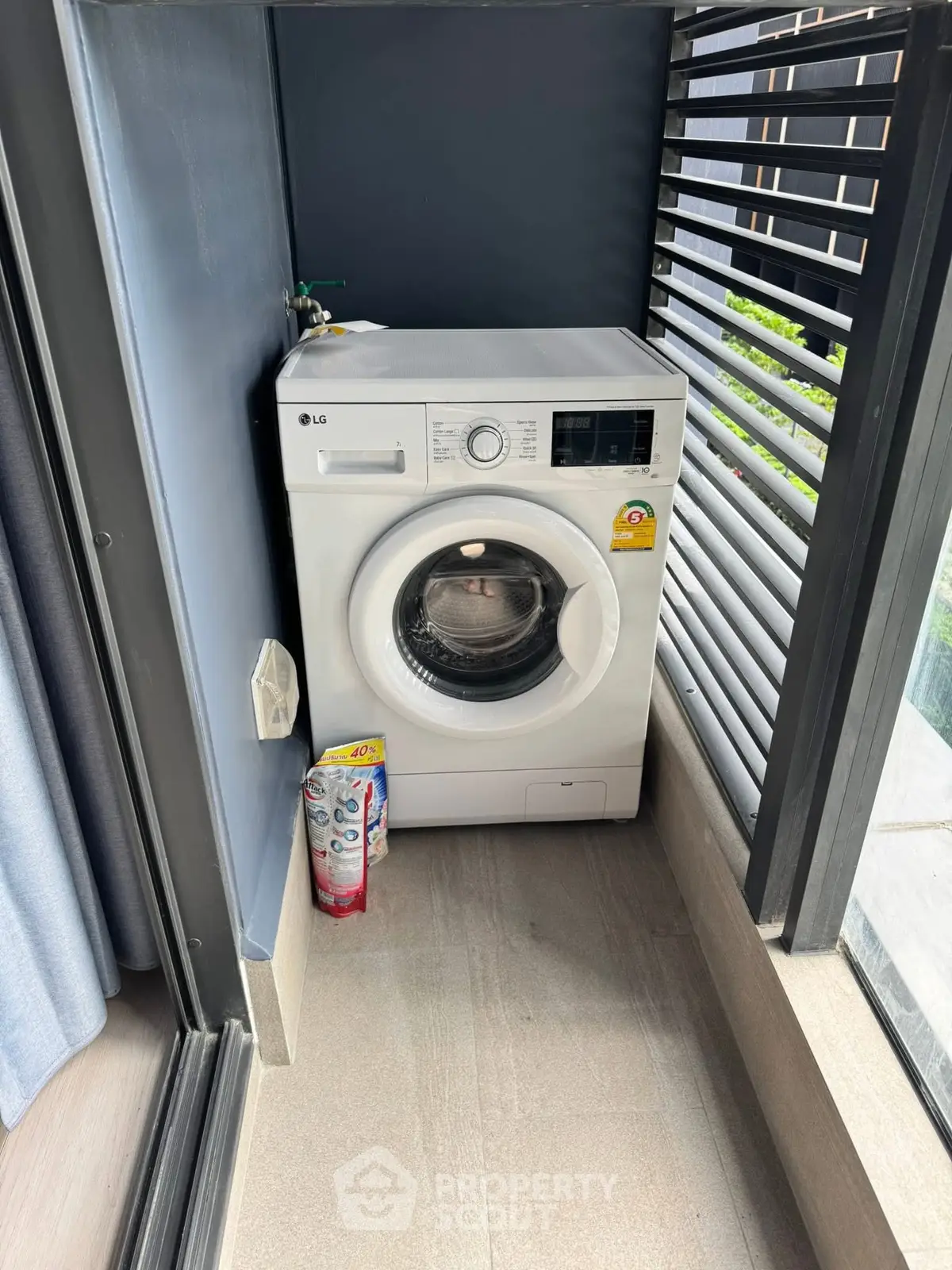 Modern washing machine in a sleek balcony space with stylish louvered design.