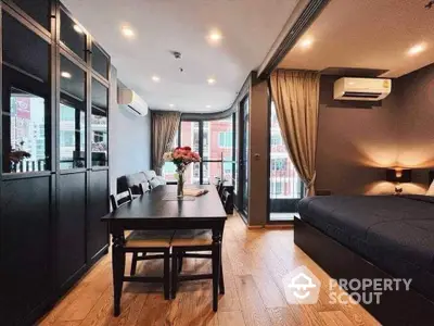 Modern studio apartment with stylish decor and large windows for natural light.