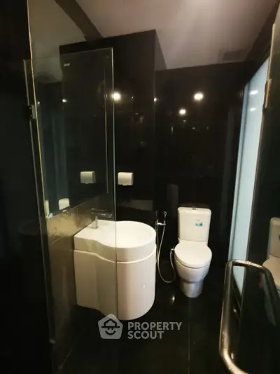 Modern bathroom with sleek black tiles and contemporary fixtures.