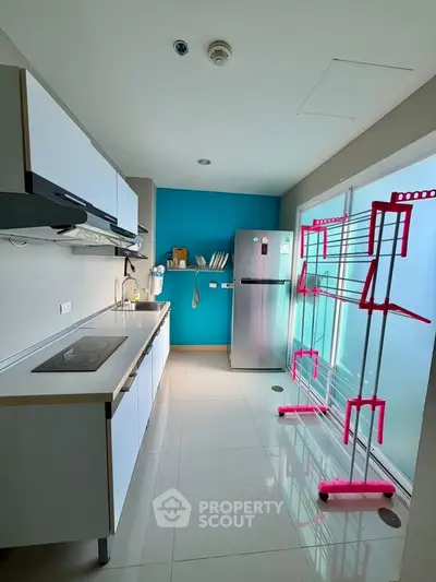 Modern kitchen with sleek appliances and vibrant blue accent wall