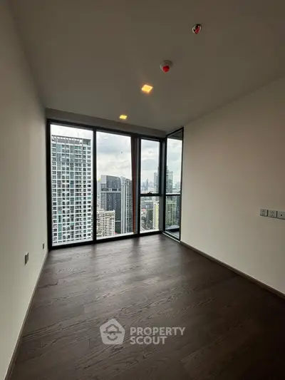 Spacious modern apartment with floor-to-ceiling windows offering stunning city views.