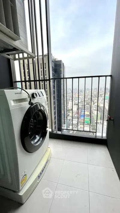 High-rise apartment balcony with city view and washing machine.