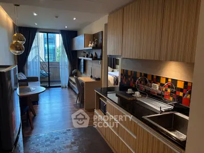 Modern open-layout kitchen and living room with stylish decor and balcony view.