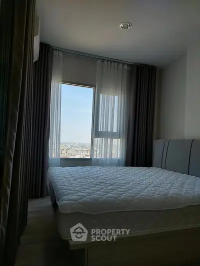 Modern bedroom with large window offering stunning city view, featuring a comfortable bed and elegant curtains.