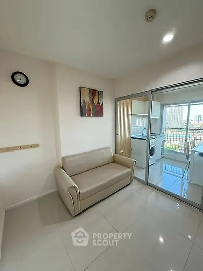 Modern living room with beige sofa and glass sliding doors to kitchen
