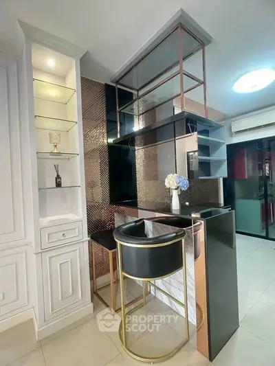 Stylish modern kitchen with sleek bar counter and elegant shelving in a contemporary apartment.