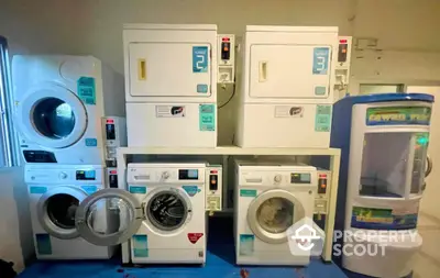 Laundry room with multiple washing machines and dryers in a real estate property.