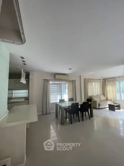 Spacious living room with dining area and natural light, ideal for family gatherings.