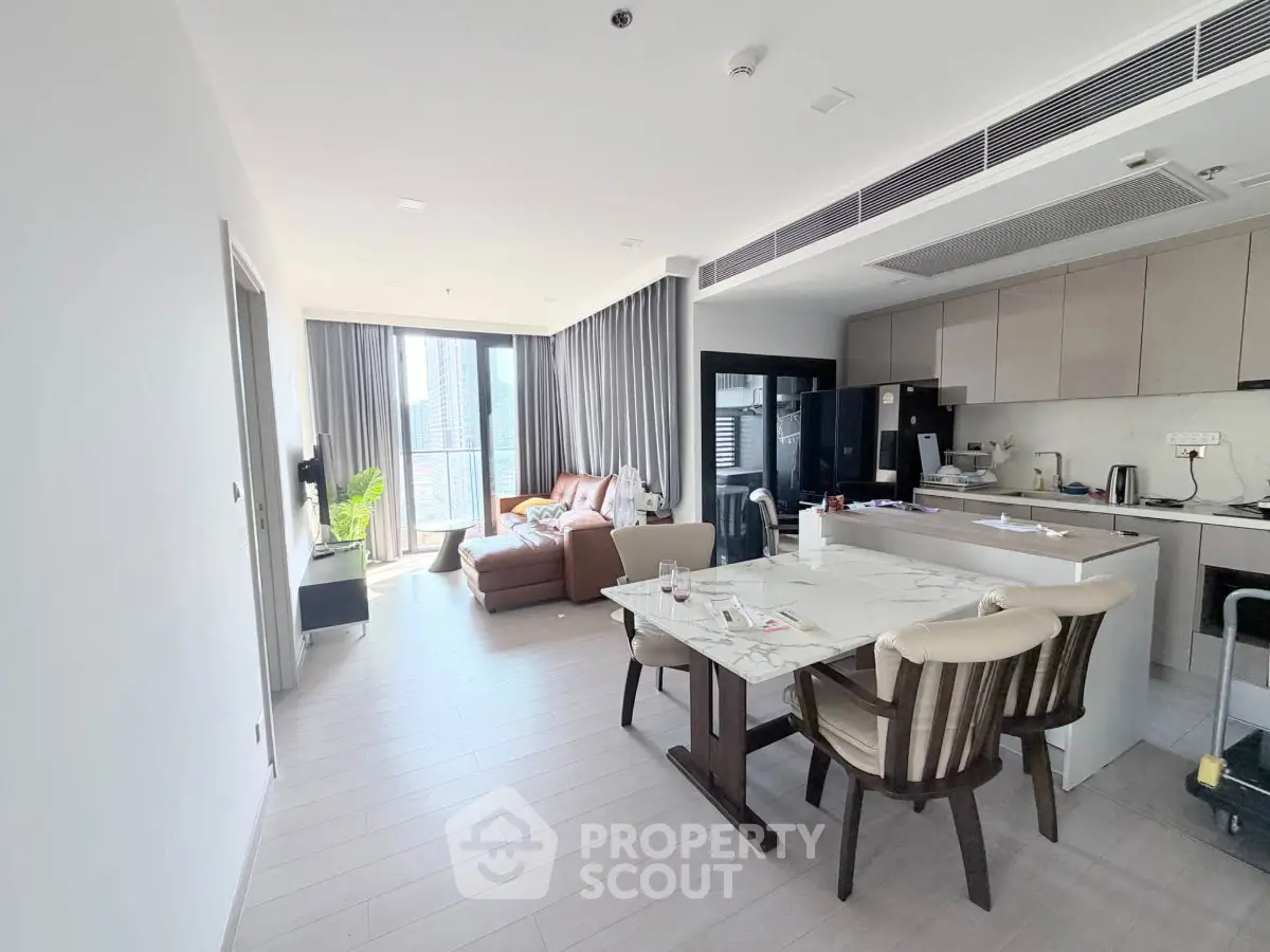 Modern open-layout living room and kitchen with sleek design and natural light.