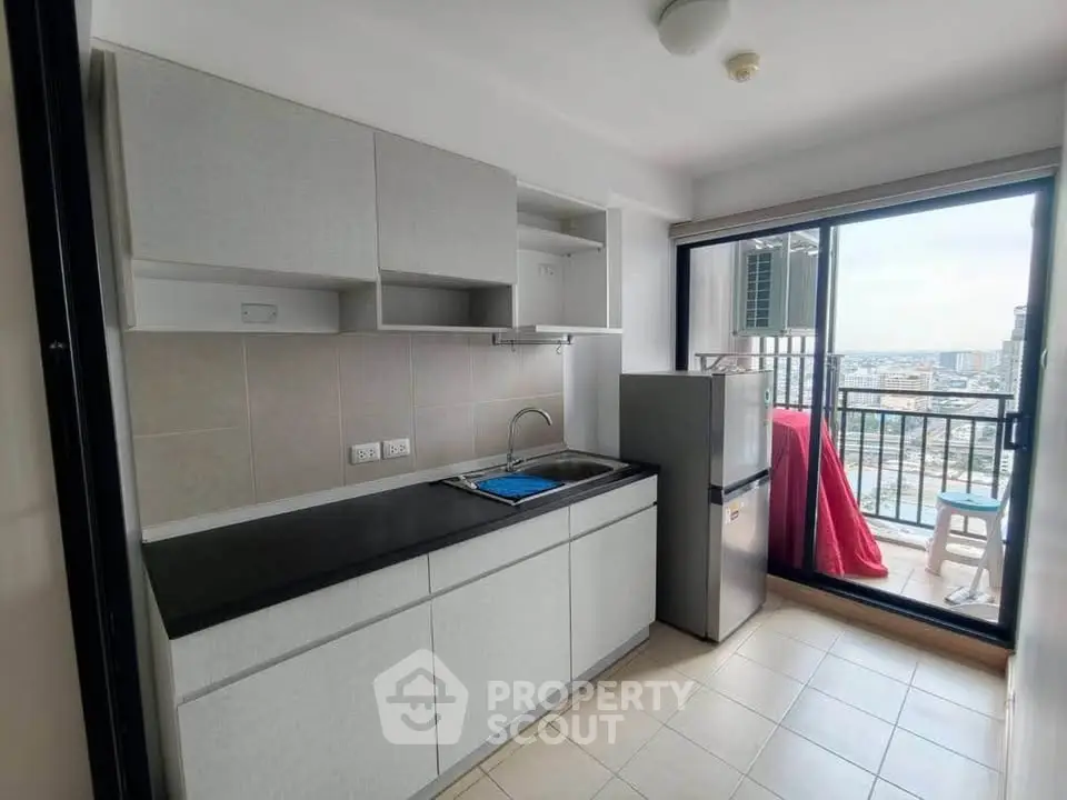 Modern kitchen with balcony view in high-rise apartment