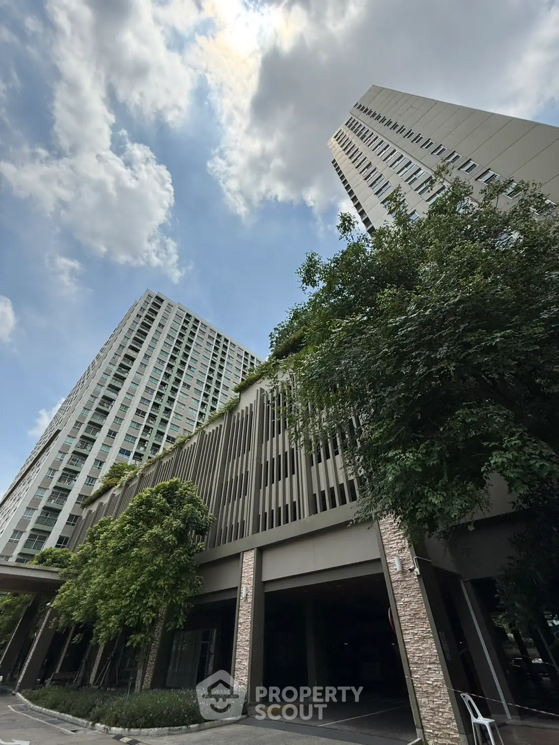 Modern high-rise buildings with lush greenery and clear blue sky